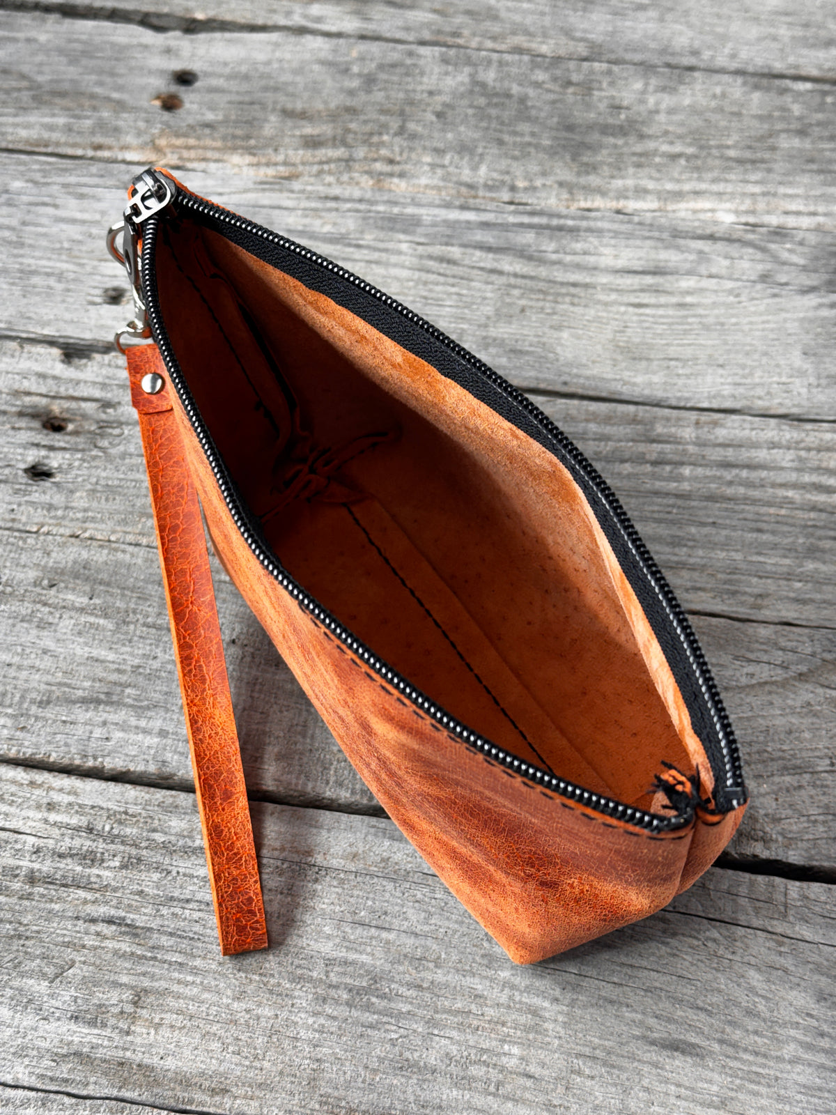 Large orange leather cosmetic bag with natural leather texture and detachable strap