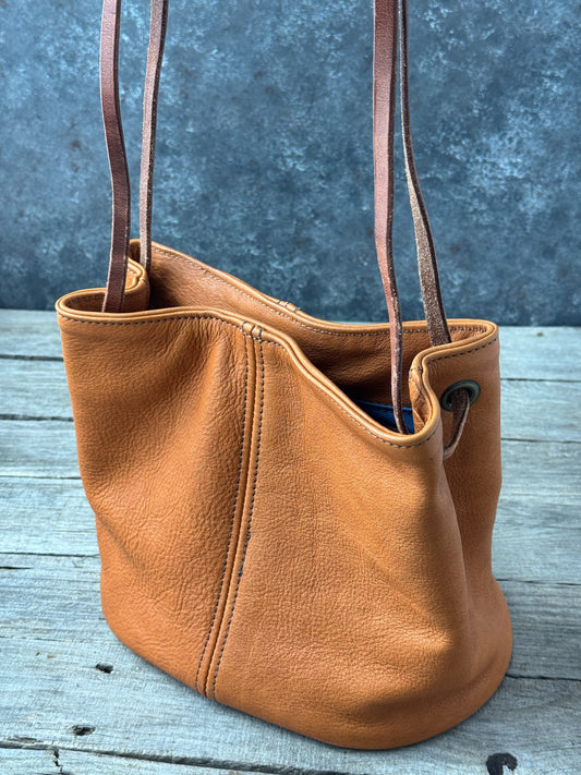 Saddle tan full grain leather bucket shoulder purse side view