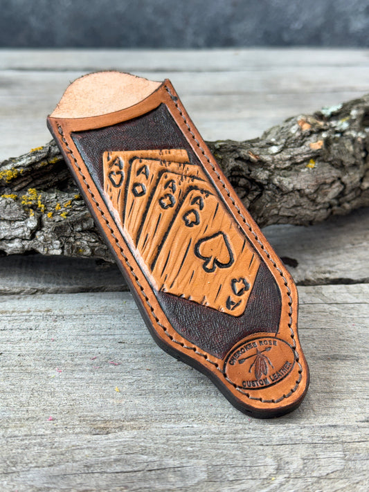 custom leather tooled cast iron skillet handle with playing card design on a wooden surface