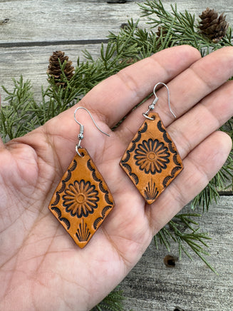 Diamond-shaped leather earrings with stamped flower design and sterling silver ear wires, handmade by Cherokee Rose Custom Leather in East Texas.