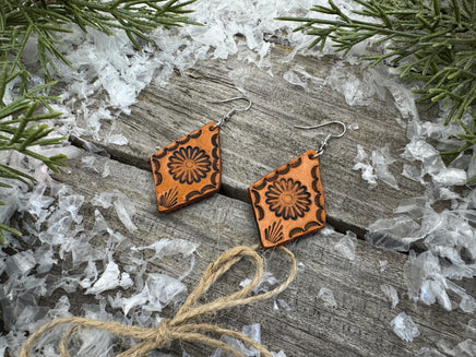 Diamond-shaped leather earrings with stamped flower design and sterling silver ear wires, handmade by Cherokee Rose Custom Leather in East Texas.
