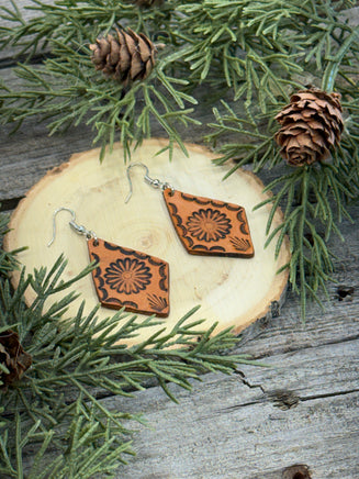 Diamond-shaped leather earrings with stamped flower design and sterling silver ear wires, handmade by Cherokee Rose Custom Leather in East Texas.