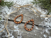 Teardrop-shaped leather earrings with hand-stamped dotted border and sterling silver ear wires, handmade by Cherokee Rose Custom Leather in East Texas.