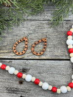 Teardrop-shaped leather earrings with hand-stamped dotted border and sterling silver ear wires, handmade by Cherokee Rose Custom Leather in East Texas.