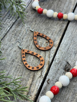 Teardrop-shaped leather earrings with hand-stamped dotted border and sterling silver ear wires, handmade by Cherokee Rose Custom Leather in East Texas.