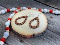 Teardrop-shaped leather earrings with hand-stamped dotted border and sterling silver ear wires, handmade by Cherokee Rose Custom Leather in East Texas.