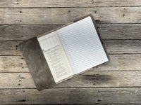 Open leather notebook on a wooden surface