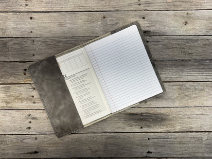 Open leather notebook on a wooden surface