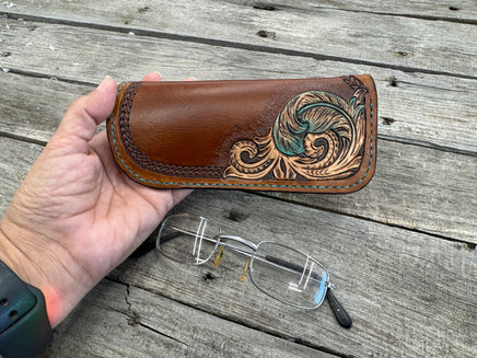 Hand tooled leather eyeglasses case with turquoise feather and floral corner design, handmade by Cherokee Rose Custom Leather