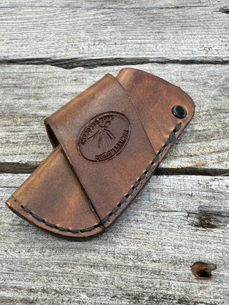 Handmade rustic brown leather knife sheath with black rivet hardware, horizontal carry design for small pocket knives by Cherokee Rose Custom Leather.