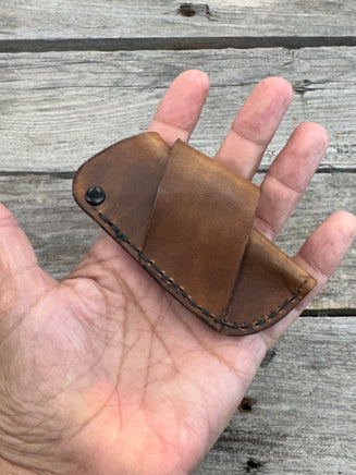 Handmade rustic brown leather knife sheath with black rivet hardware, horizontal carry design for small pocket knives by Cherokee Rose Custom Leather.
