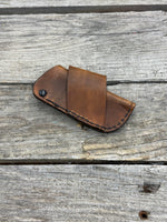 Handmade rustic brown leather knife sheath with black rivet hardware, horizontal carry design for small pocket knives by Cherokee Rose Custom Leather.