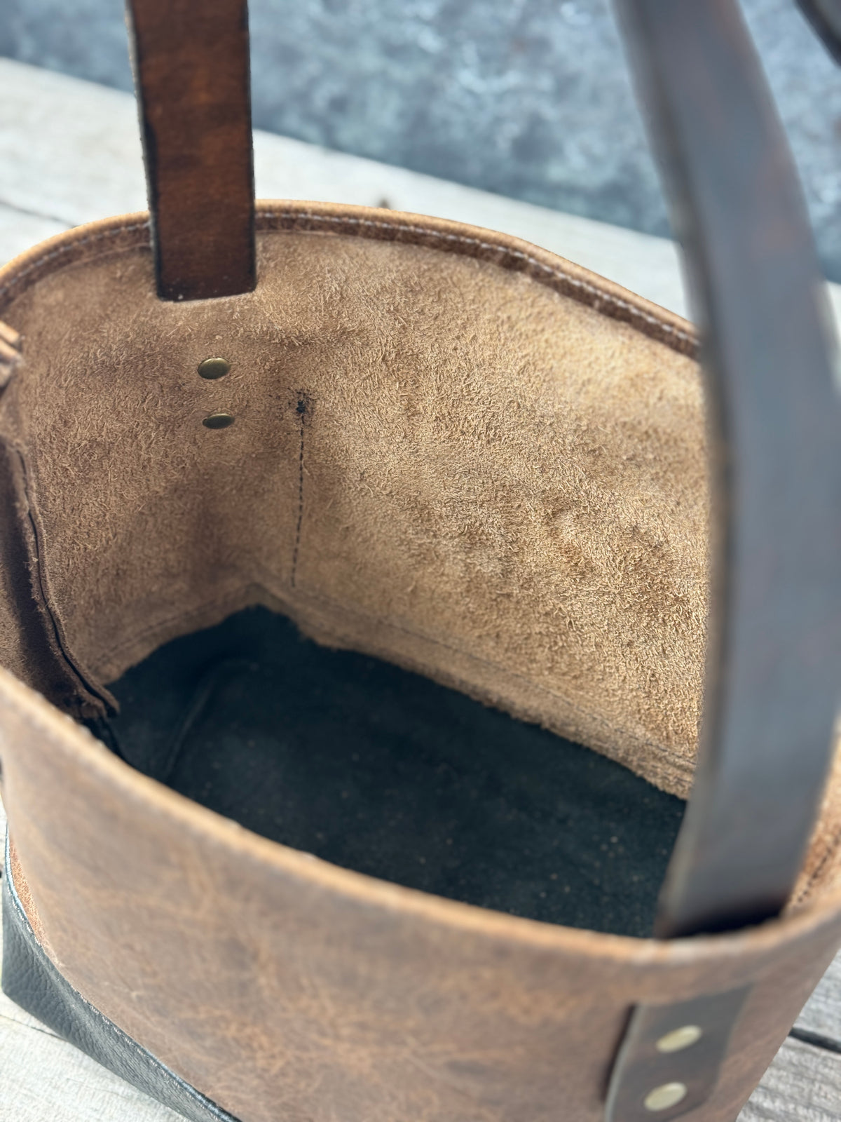 Unlined interior of mini bison leather tote with open top and black leather bottom