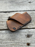 Handmade rustic brown leather knife sheath with black rivet hardware, horizontal carry design for small pocket knives by Cherokee Rose Custom Leather.
