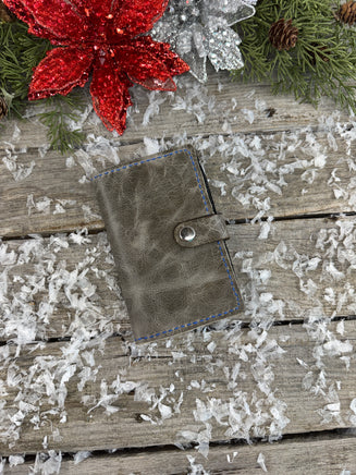 Handmade grey oil-tanned leather memo pad holder with black pigskin interior, royal blue stitching, and silver snap closure by Cherokee Rose Custom Leather.
