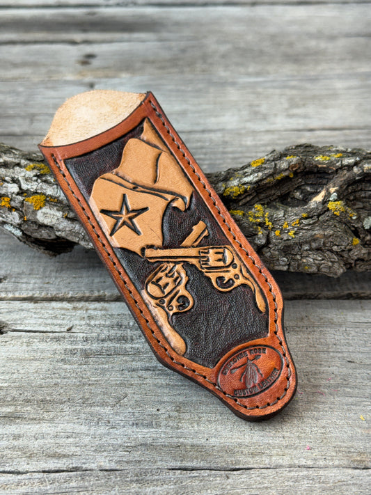 Custom leather carved cast iron skillet handle with a Texas flag design on a wooden background