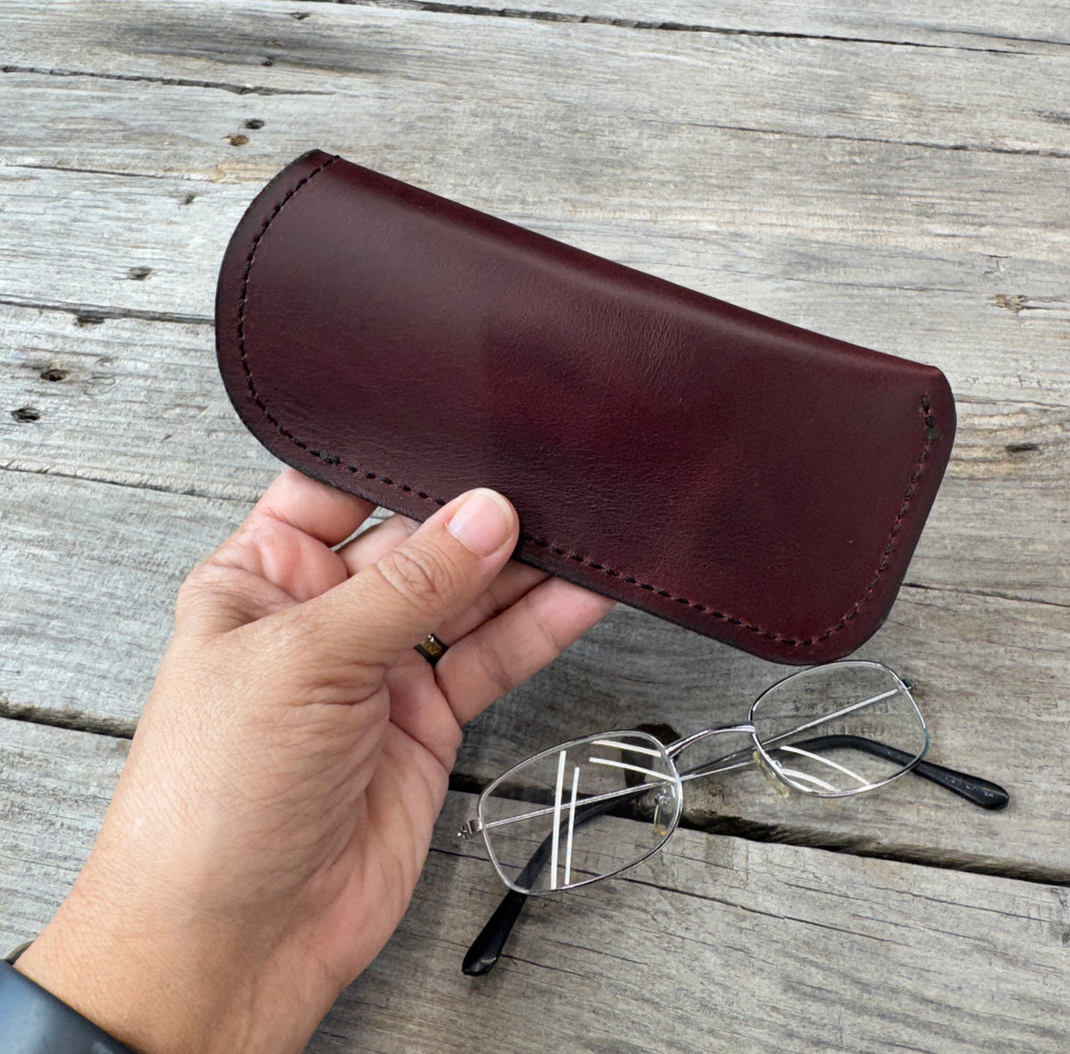 Bayou Red full grain leather eyeglass case held in hand