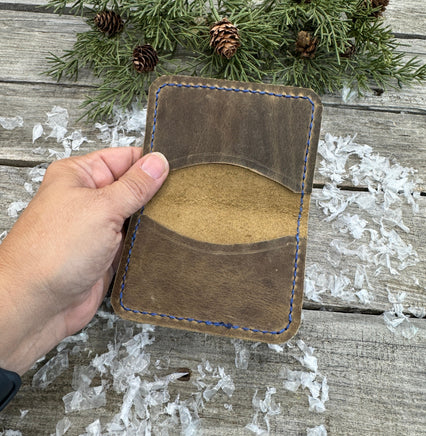 Rustic beige oil-tanned leather card wallet with blue hand stitching, handmade by Cherokee Rose Custom Leather in East Texas.