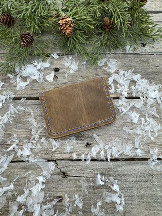 Rustic beige oil-tanned leather card wallet with blue hand stitching, handmade by Cherokee Rose Custom Leather in East Texas.