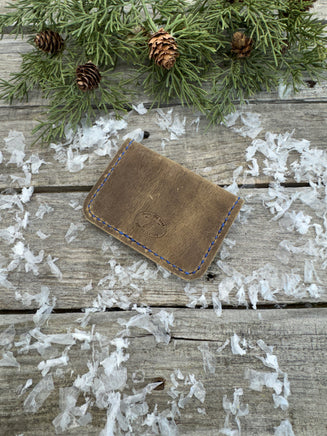 Rustic beige oil-tanned leather card wallet with blue hand stitching, handmade by Cherokee Rose Custom Leather in East Texas.