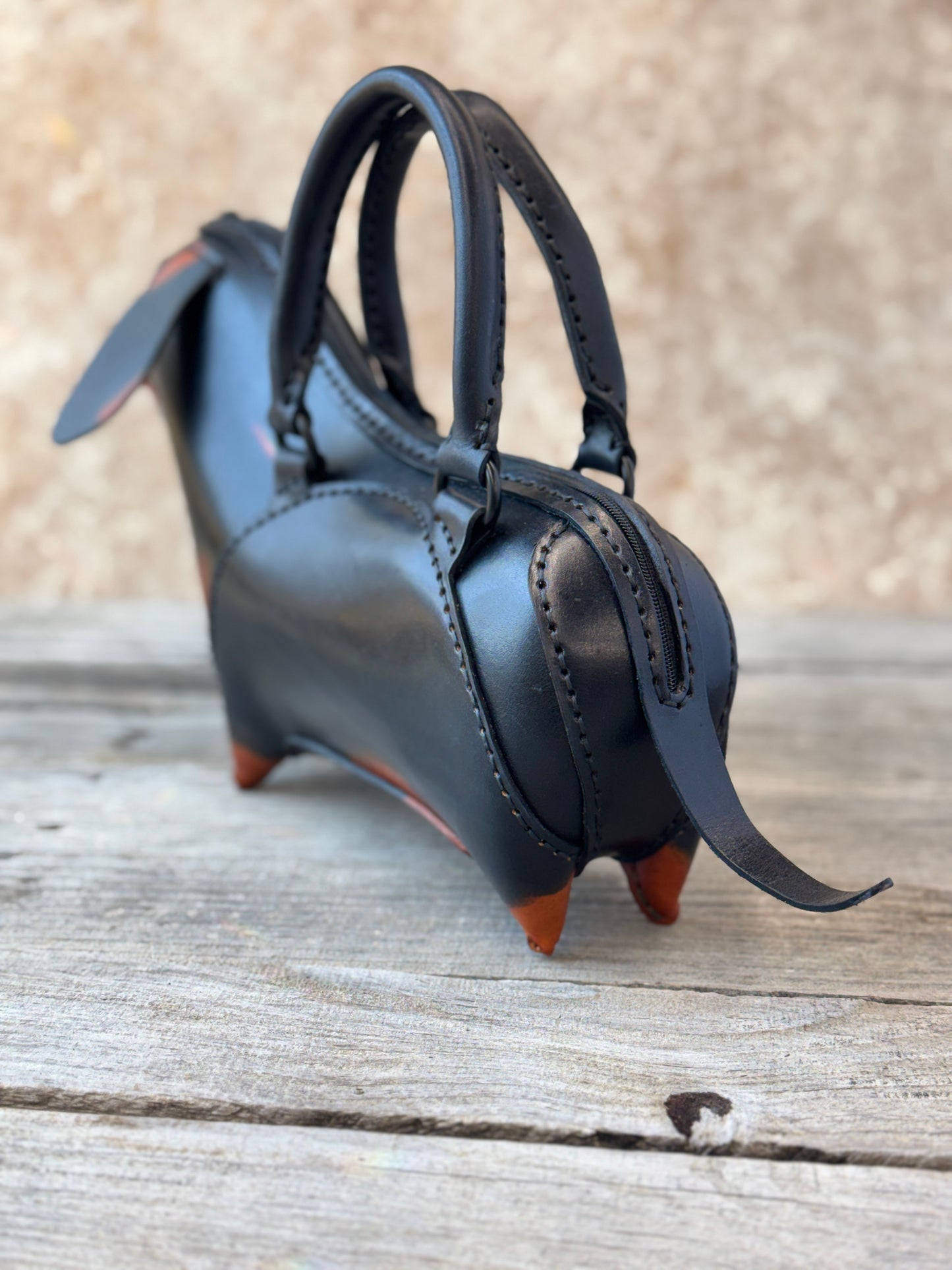 Black and tan leather dachshund handbag showing back zipper details and hand stitched construction