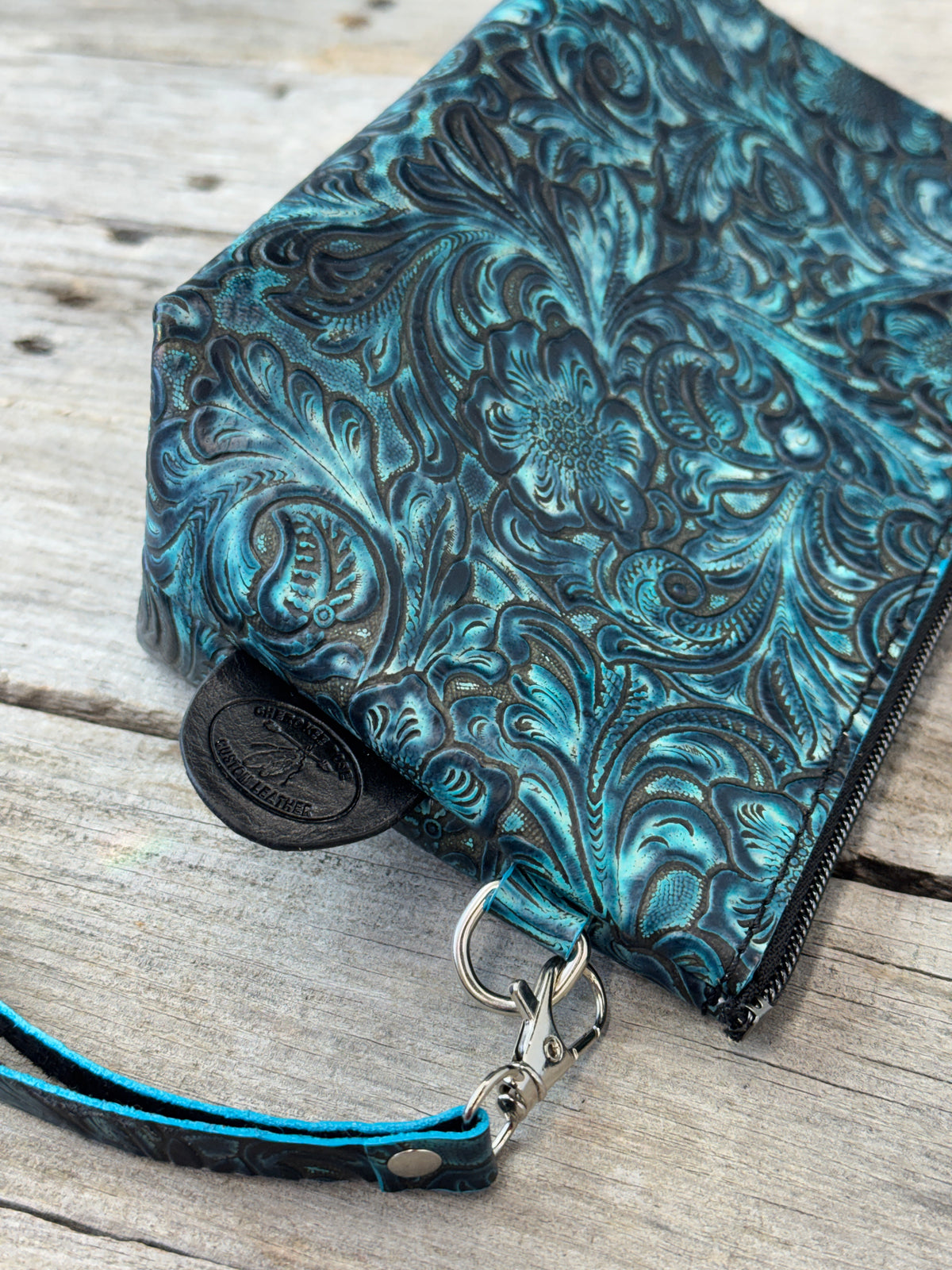 Close view of turquoise floral embossed genuine leather cosmetic pouch
