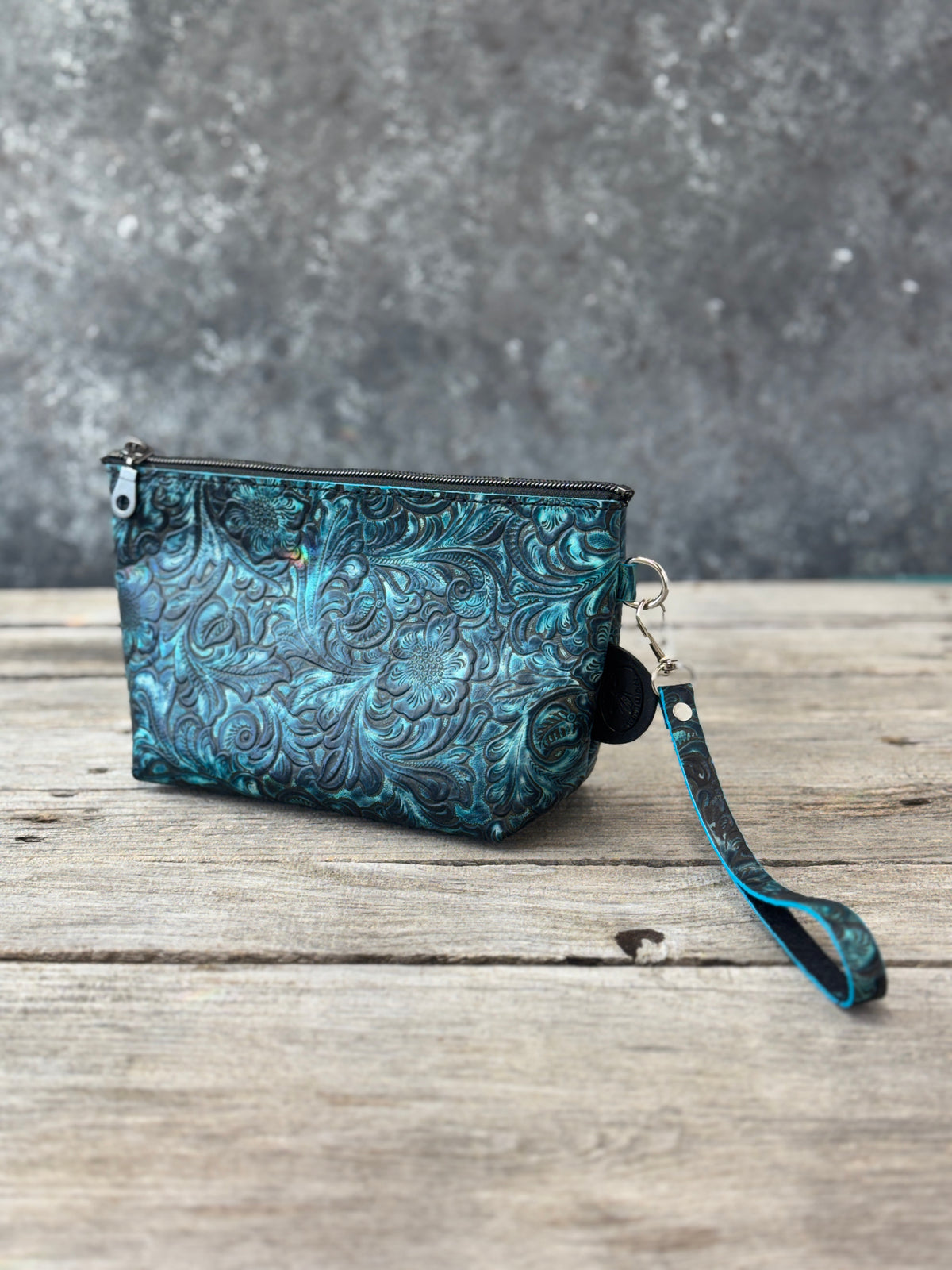 Turquoise and black embossed floral leather cosmetic wristlet bag