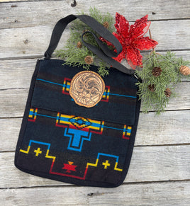 Black woven Southwest messenger bag with hand-tooled leather floral patch and yellow stitching, handmade by Cherokee Rose Custom Leather in East Texas.