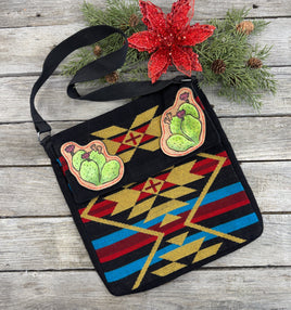 Southwest woven messenger bag with two hand-tooled and painted cactus leather patches stitched in red thread by Cherokee Rose Custom Leather.