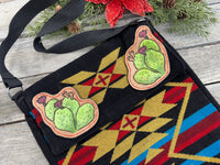 Southwest woven messenger bag with two hand-tooled and painted cactus leather patches stitched in red thread by Cherokee Rose Custom Leather.