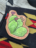 Southwest woven messenger bag with two hand-tooled and painted cactus leather patches stitched in red thread by Cherokee Rose Custom Leather.