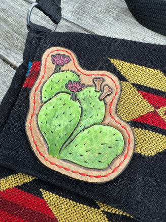 Southwest woven messenger bag with two hand-tooled and painted cactus leather patches stitched in red thread by Cherokee Rose Custom Leather.