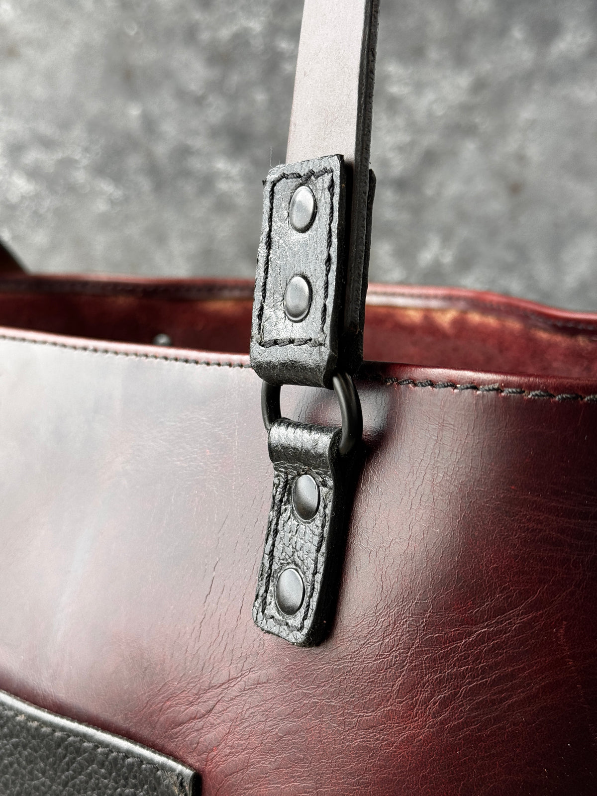 Burgundy leather shoulder bag with contrasting black textured leather pocket and black hardware