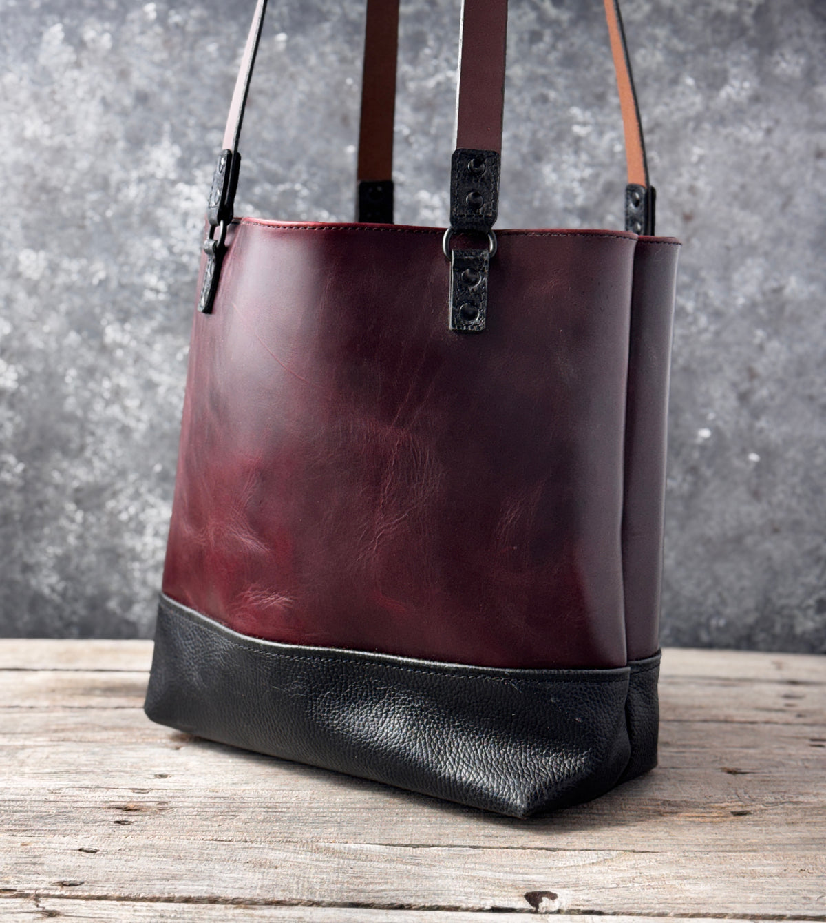 Open top burgundy leather tote with long brown leather shoulder straps