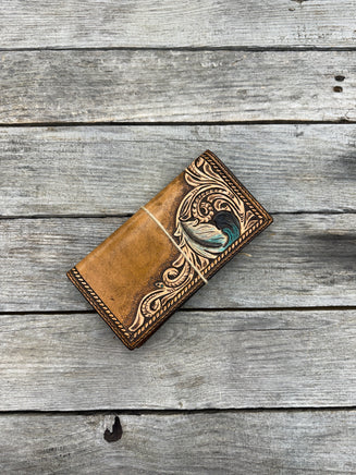 Brown leather wallet with intricate designs on a wooden surface