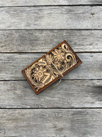 Wooden wallet with floral patterns on a wooden surface