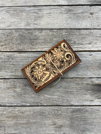 Wooden wallet with floral patterns on a wooden surface