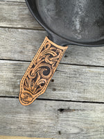 Hand tooled leather cast iron skillet handle cover with floral scroll carving and dyed background, handmade by Cherokee Rose Custom Leather in East Texas.