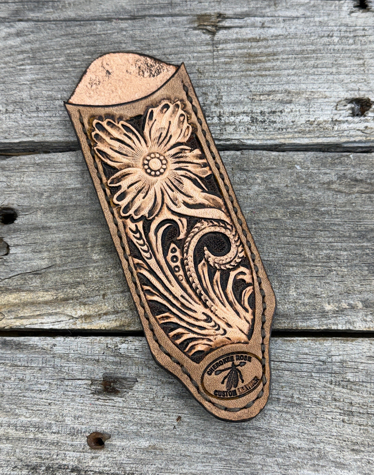 Decorative leather stamp with floral patterns on a wooden surface