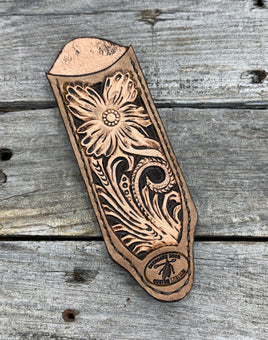 Decorative leather stamp with floral patterns on a wooden surface