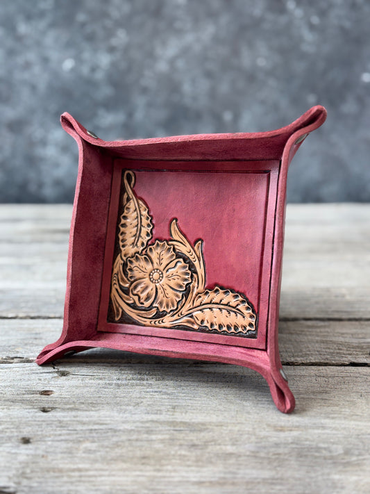 Custom leather valet tray with a hand carved floral design on a wooden surface