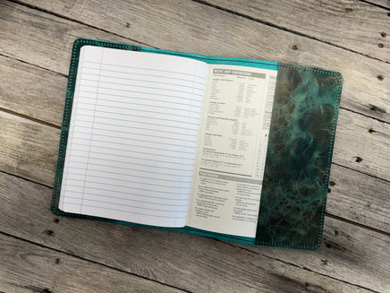 Open notebook with lined pages on a wooden surface