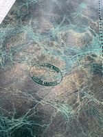 Close-up of a leather product with a visible brand stamp on a textured surface.