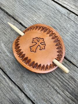 Hand stamped leather hair barrette with cross and sunburst border, oval shape with bamboo hair stick.