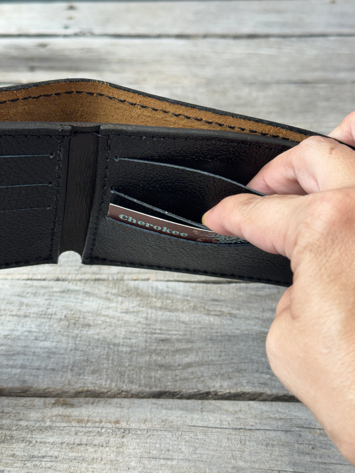 Dark brown bifold wallet showing pigskin card slots and hidden interior pockets