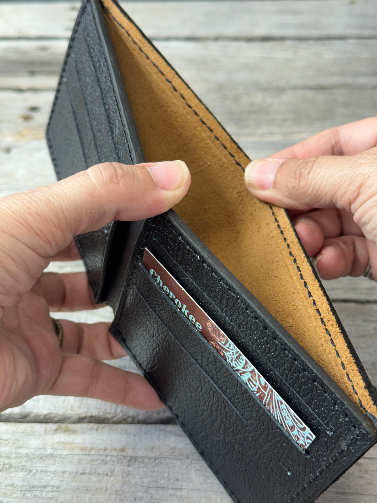 Dark brown leather bifold wallet with textured black pigskin interior