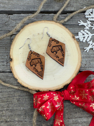Diamond-shaped light tan leather earrings with hand-stamped bison, arrows, and tribal geometric design, handmade by Cherokee Rose Custom Leather in East Texas.
