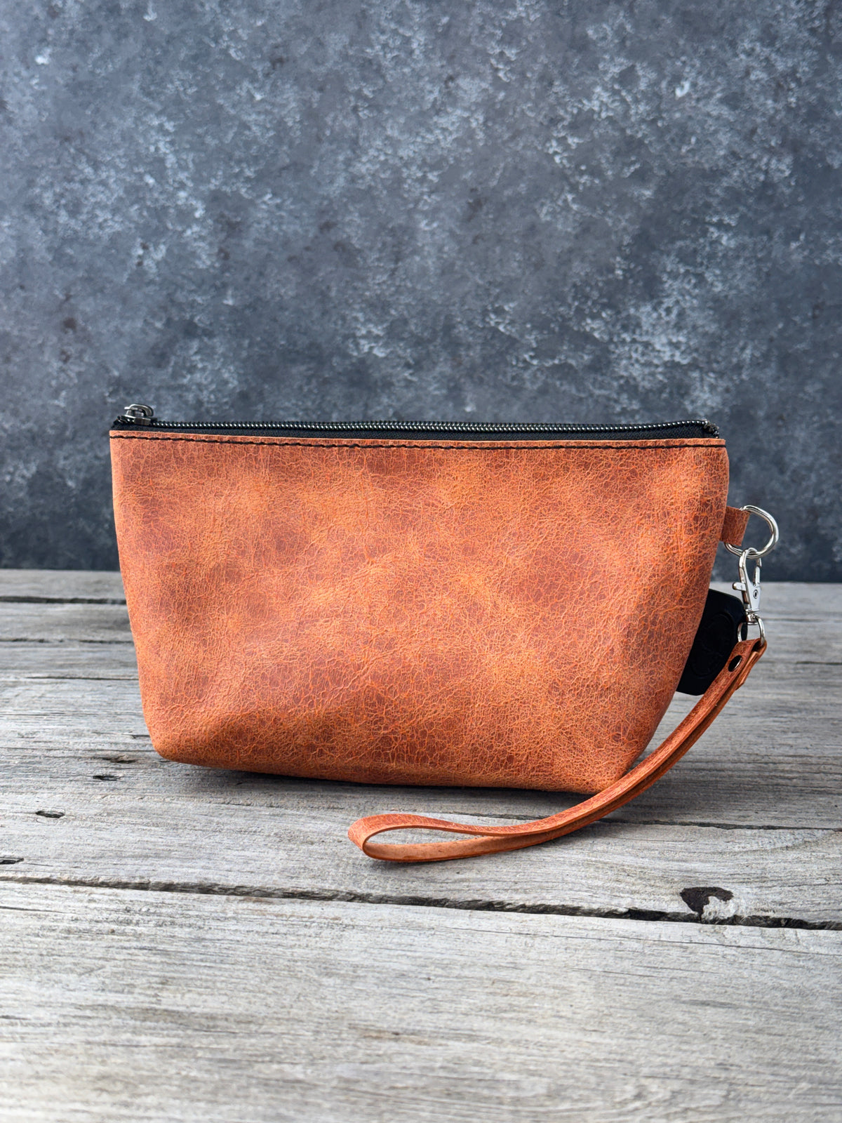 Medium distressed orange leather cosmetic bag with black zipper
