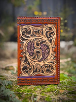 Hand-carved leather field notes cover with Western floral and feather design, purple and turquoise accents, handmade by Cherokee Rose Custom Leather.