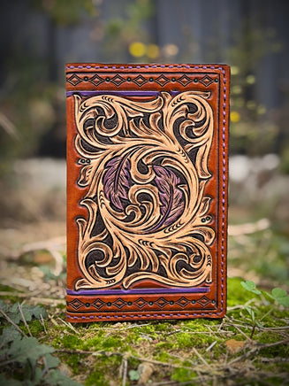 Hand-carved leather field notes cover with Western floral and feather design, purple and turquoise accents, handmade by Cherokee Rose Custom Leather.